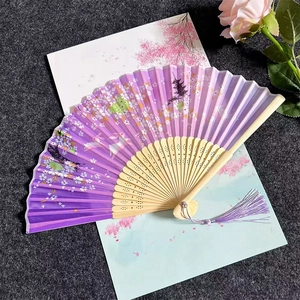 Detail of purple folding fan with cherry blossom and rabbit patterns and bamboo ribs