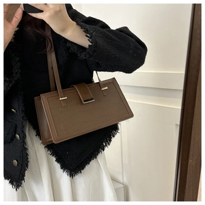 Detail of dark brown faux crocodile texture shoulder bag with gold magnetic buckle