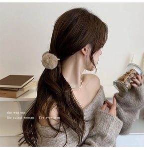 Close-up of brown plush double-ball hair tie worn on a ponytail for soft autumn styling
