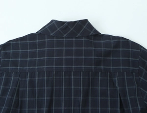 Detail of navy blue plaid poplin shirt back yoke and pleated design on cotton fabric