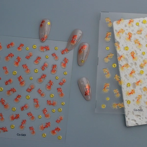 Detail of red and gold koi fish nail stickers with circular accents on grey nail tips