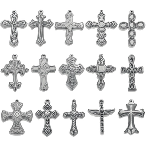 Variety of vintage silver cross pendants with embossed textures on a white background