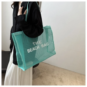 Detail shot of mint green mesh beach bag showing the large capacity and stylish lettering