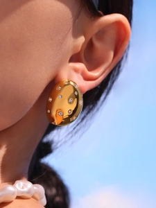 Close-up of 18k gold plated oval earrings with sparkling crystals on female model
