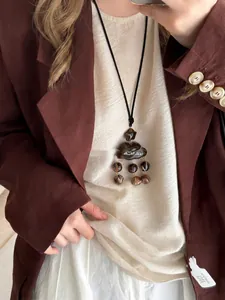 Détail du pendentif nuage en résine ambrée sur cordon noir avec pompon perlé