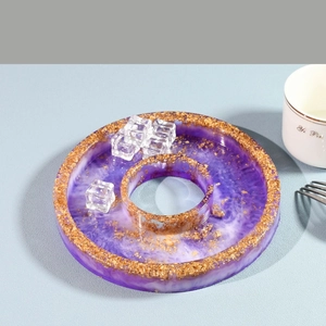 Detailed view of a purple resin coaster with gold foil edges and a central hole