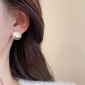Close-up of minimalist gold pearl stud earring worn by model in a daily elegant style