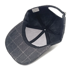 Detail view of plaid baseball cap showing 100% polyester label and mesh interior support