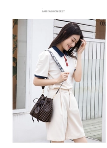 Detail of checkered bucket bag featuring leather drawstring and logo patterned strap