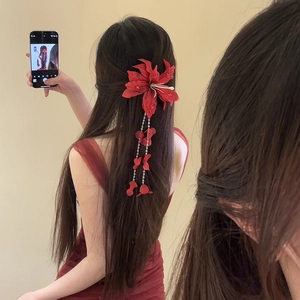 Red fabric Lycoris flower hair clip with long tassel pendant worn by a model