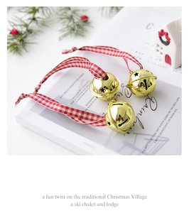 Golden Christmas bell with red plaid ribbon on a decorative festive background