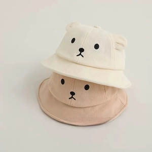 Detail of cute bear ear baby sun hats in cream and light brown with embroidered faces