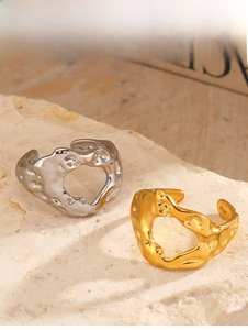 Close-up of gold and silver irregular heart rings with a molten lava textured finish