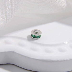 Dettaglio macro di una perla distanziatrice in argento S925 con cristalli verde smeraldo