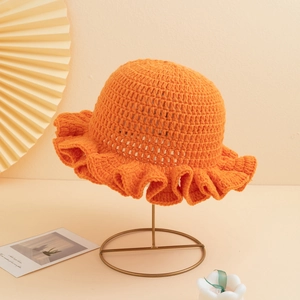 Handcrafted orange crochet knit bucket hat featuring elegant ruffled wavy brim for women