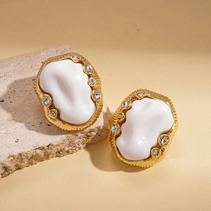 Close-up of vintage oval acrylic stud earrings with gold base and crystal accents