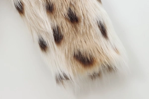 Macro detail of plush faux fur fabric with leopard print texture and soft fibers