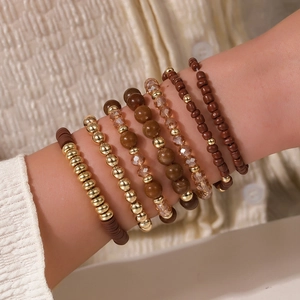 Detail of bohemian layered acrylic crystal bead bracelets in coffee and gold tones