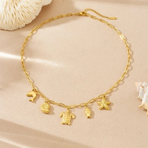 Gold stainless steel paperclip chain necklace with sea animal charms on beige background