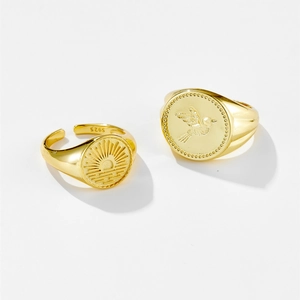 Vintage 18K gold plated adjustable rings with sun and bird relief on white background