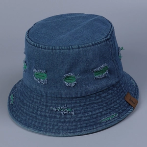Close-up of distressed denim bucket hat with green fabric underlay and leather patch