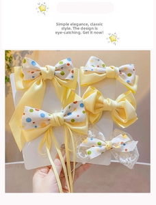 Detail of yellow fabric hair bow clips with colorful polka dots and lace trim