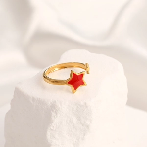 Detailed shot of gold-plated open ring featuring a bright red enamel star and textured finish
