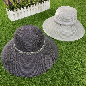 Detailed close-up of wide-brim straw hat with sparkling rhinestone trim for sun protection