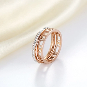 Detail of rose gold two-in-one ring with Roman numerals and crystals on beige silk