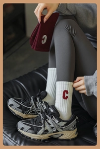 Détail de chaussettes en coton blanc avec lettre C brodée et chaussures de sport