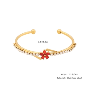 Detail of gold stainless steel flower bangle with red zircon and sparkling rhinestones