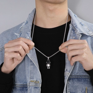 Close-up of astronaut pendant with star detail on stainless steel curb chain