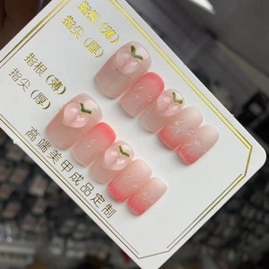 Détail de faux ongles faits main avec dégradé rose, décorations de pêche 3D et gouttes
