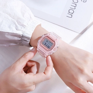 Transparent pink square digital sports watch worn on wrist with LED display