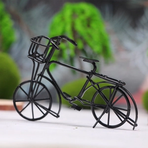 Detailed macro shot of a black vintage metal miniature bicycle model for dollhouse scenes