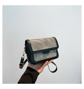 Detail of stylish contrast grey and black crossbody bag with adjustable leather strap