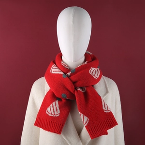 Close-up of red knitted scarf featuring white fan pattern and ribbed edge detail