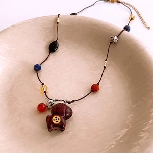 Macro detail of wooden pony pendant necklace with colorful glass beads and ethnic folk style