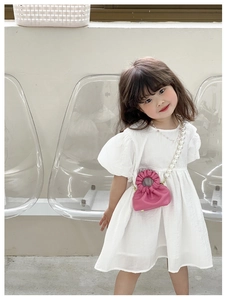 Pink pleated girls handbag with pearl strap on a white dress for kids fashion accessories