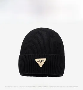 Close-up of black ribbed knit beanie with a triangular leather patch detail