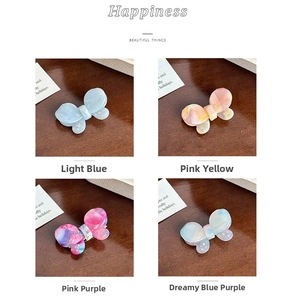 Detailed view of four acetate butterfly hair clips with sparkling rhinestone accents