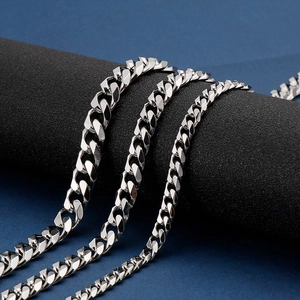 Detailed close-up of silver Cuban link chains in various sizes on a black stand