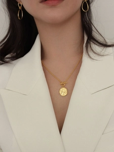 Detail of 925 silver gold-plated OT buckle necklace and knot earrings on a model
