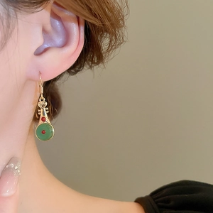 Détail de boucles d'oreilles en forme de luth avec placage d'or et incrustation de jade