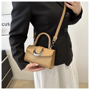 Détail du sac à main kaki à texture litchi avec boucle métallique en forme de croissant