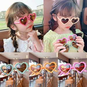 Detail view of heart-shaped kids sunglasses in pink, beige and mint green colors