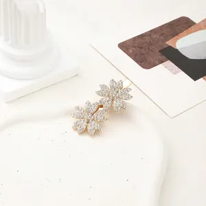 Detailed view of golden double cherry blossom hair clip with shimmering rhinestones