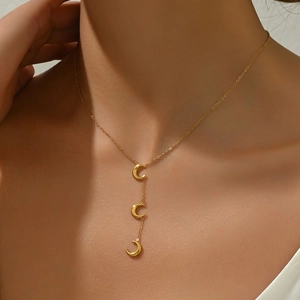 Detailed view of model wearing a gold Y-shaped necklace with three polished crescent moon charms