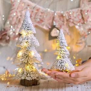 Mini flocked Christmas tree with warm LED lights and wooden base for tabletop decor