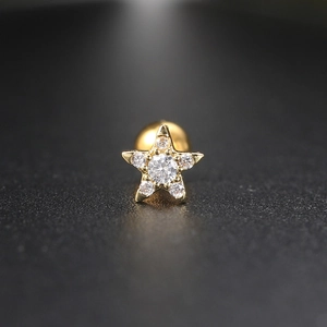 Macro view of golden star stud earring with inlaid cubic zirconia and screw-back ball